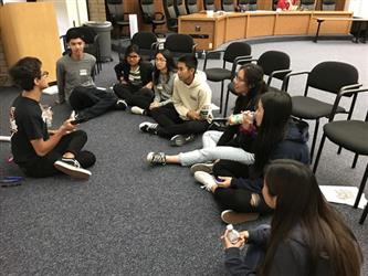 Student Governing Board/Assembly seated on carpeted floor having a discussion