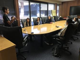 Student Governing Board/Assembly sitting at table hearing male presenter