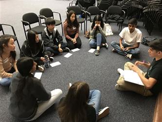 Student Governing Board/Assembly Group seated on carpeted floor having a discussion